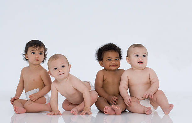 Four Multi-Ethnic Babies Sittig on White